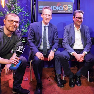 Vier Männer und eine Frau sitzen in einem Studio.