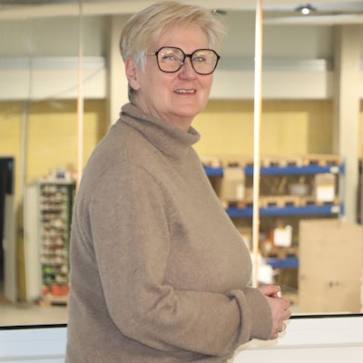 Eine Frau steht vor einem Fenster.