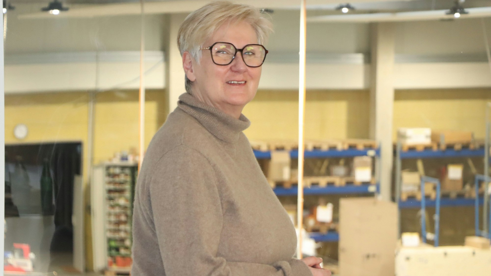 Eine Frau steht vor einem Fenster.