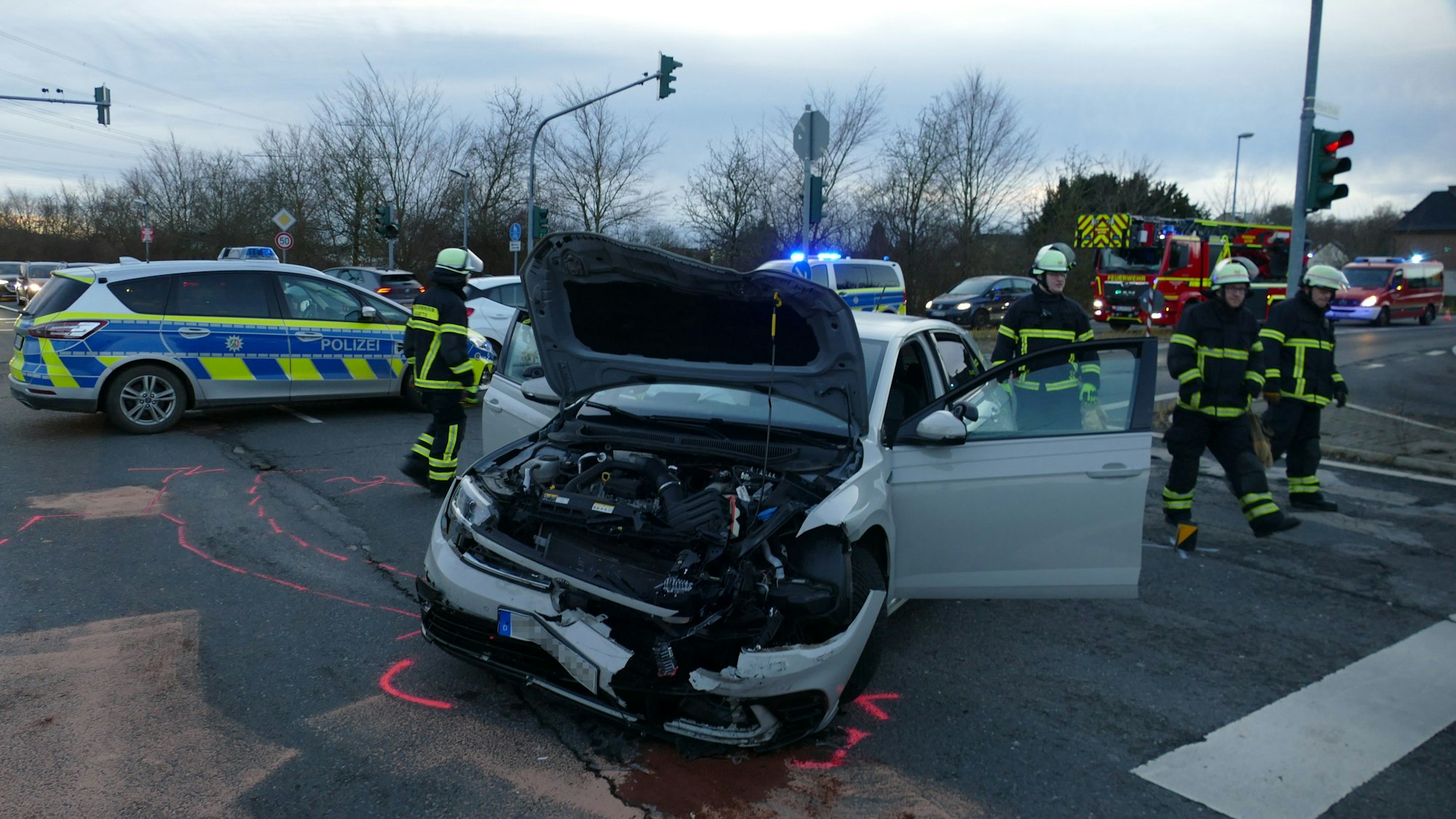 Ein beschädigter VW Golf, daneben Feuerwehrleute.