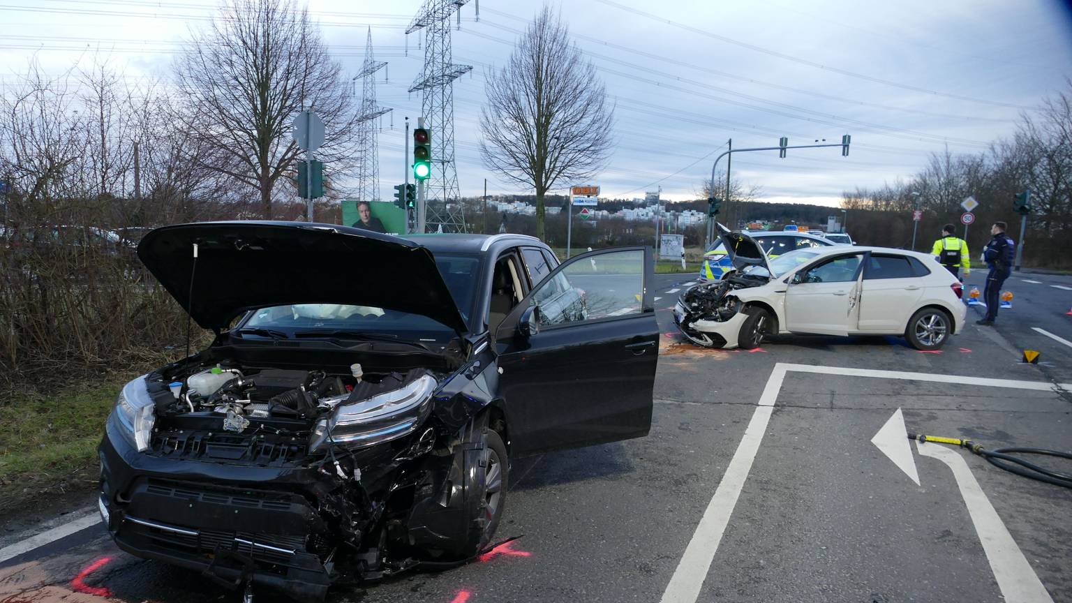 Zwei beschädigte Autos stehen auf einer Straße.