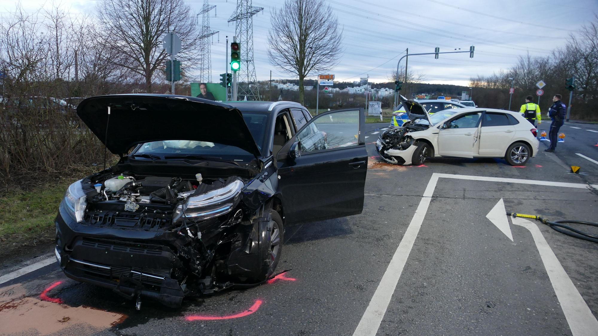 Zwei beschädigte Autos stehen auf einer Straße.