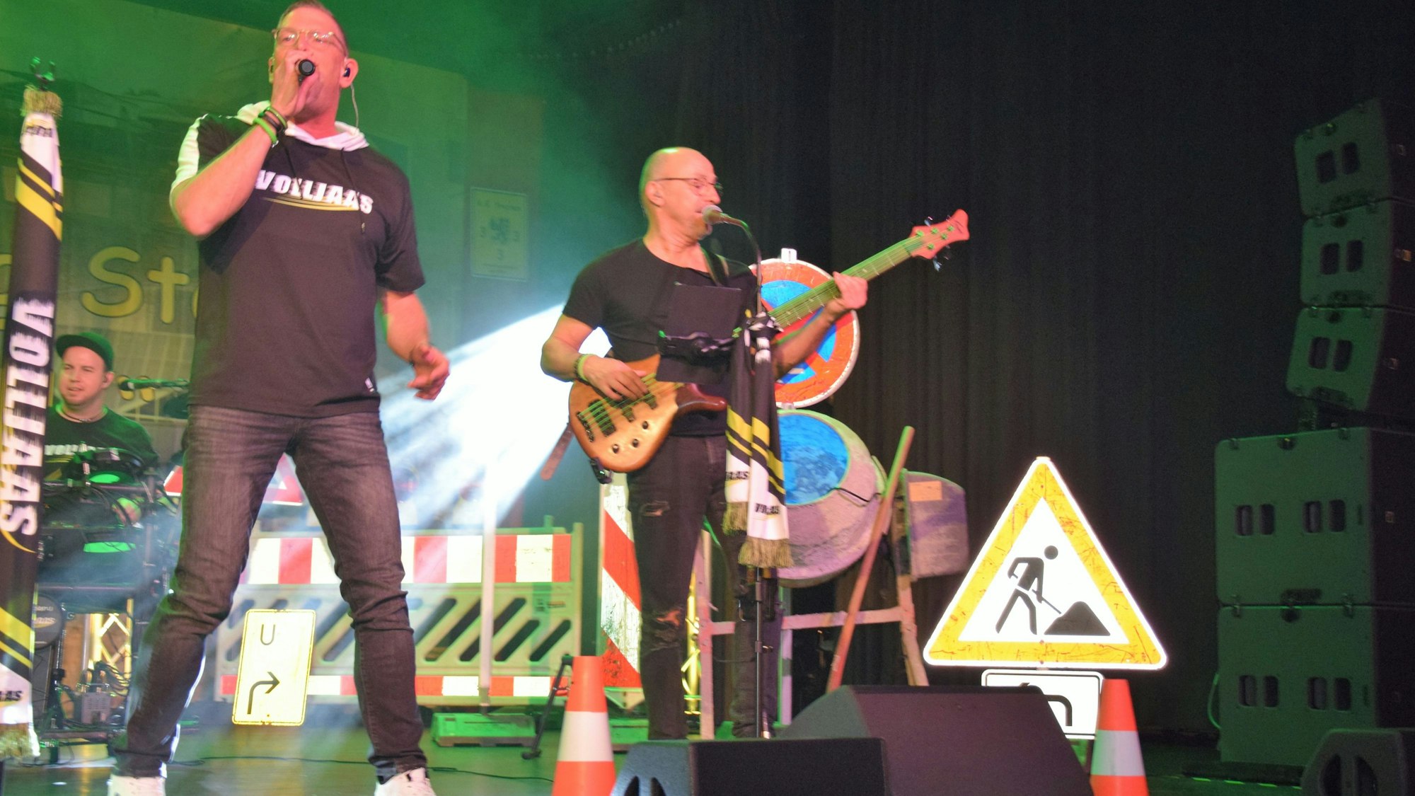 Auf dem Bild sind zwei Musiker auf der Bühne zu sehen.