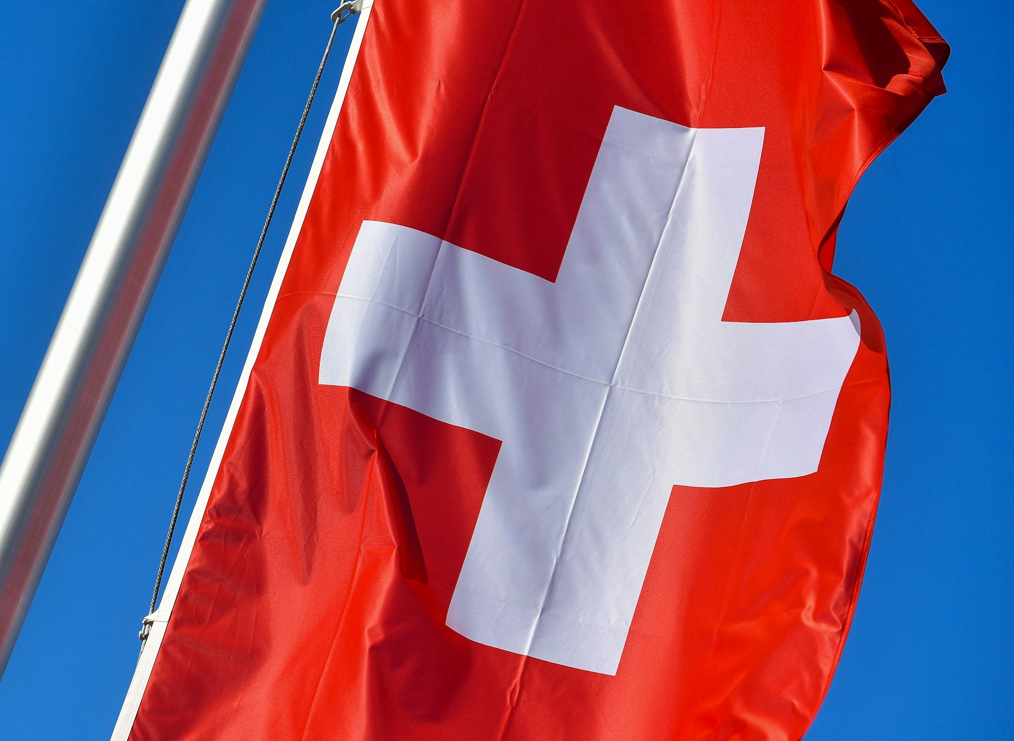 ARCHIV - 28.02.2017, Brandenburg, Rüdersdorf: Die Nationalflagge der Schweiz weht vor blauem Himmel. (zu dpa: «19-jährige Deutsche stirbt bei Absturz in Schweizer Bergen») Foto: Patrick Pleul/dpa-Zentralbild/dpa +++ dpa-Bildfunk +++