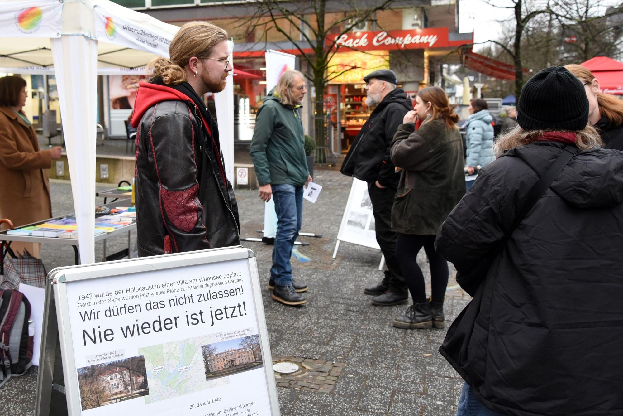 Menschen unterhalten sich vor einem Pavillon.