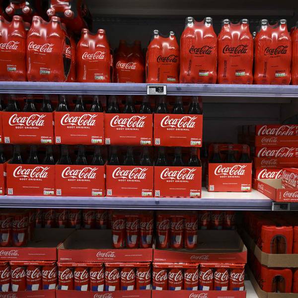 (FILES) This photograph taken on November 3, 2022 shows packs of Coca-Cola bottles on a supermarket shelf