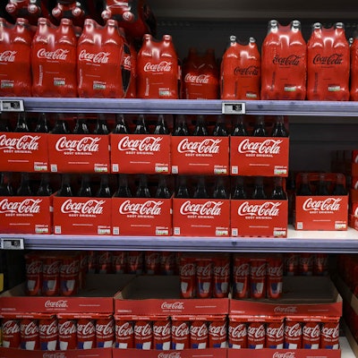 (FILES) This photograph taken on November 3, 2022 shows packs of Coca-Cola bottles on a supermarket shelf