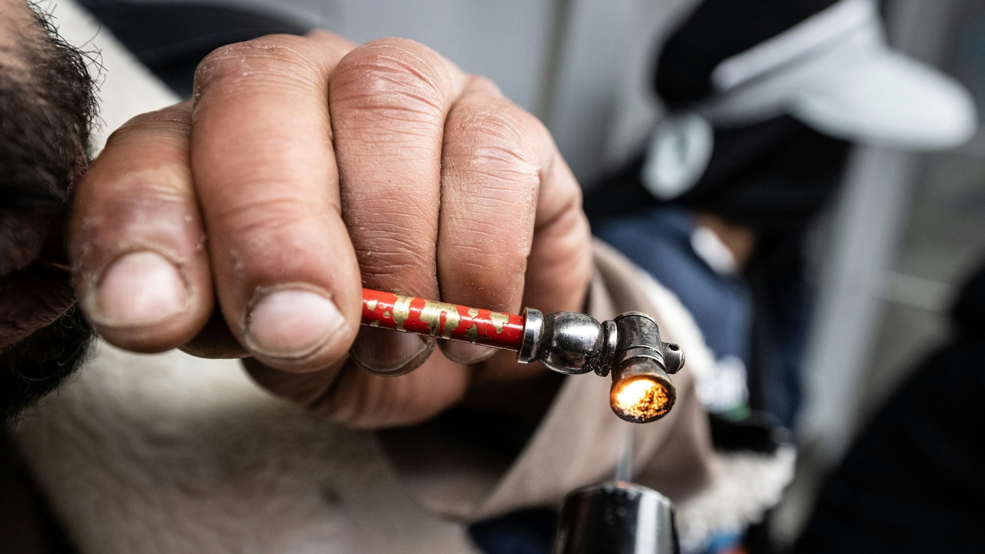 Ein Mann zieht an einer Crackpfeife.