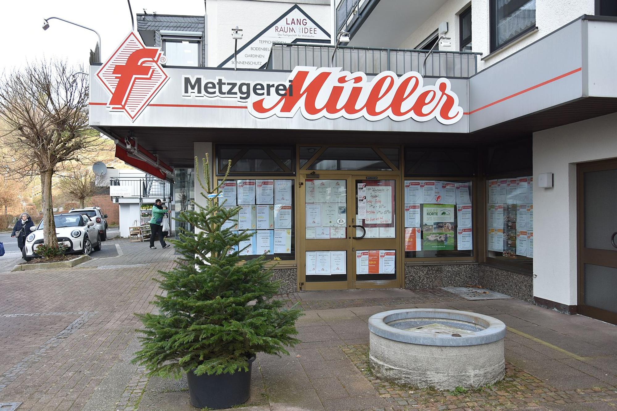 An einem geschlossenen Ladenlokal ist die Reklame der Metzgerei Müller zu sehen, die Fenster und die Türen sind mit Papier verklebt.