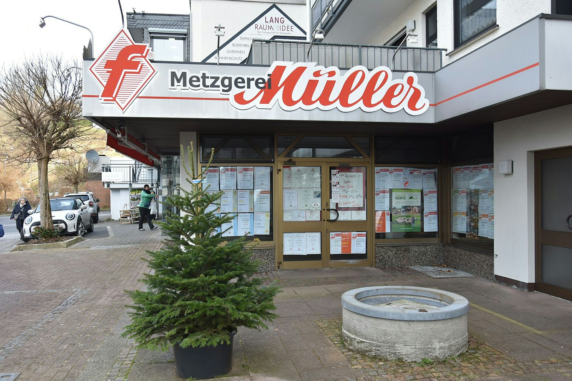 An einem geschlossenen Ladenlokal ist die Reklame der Metzgerei Müller zu sehen, die Fenster und die Türen sind mit Papier verklebt.