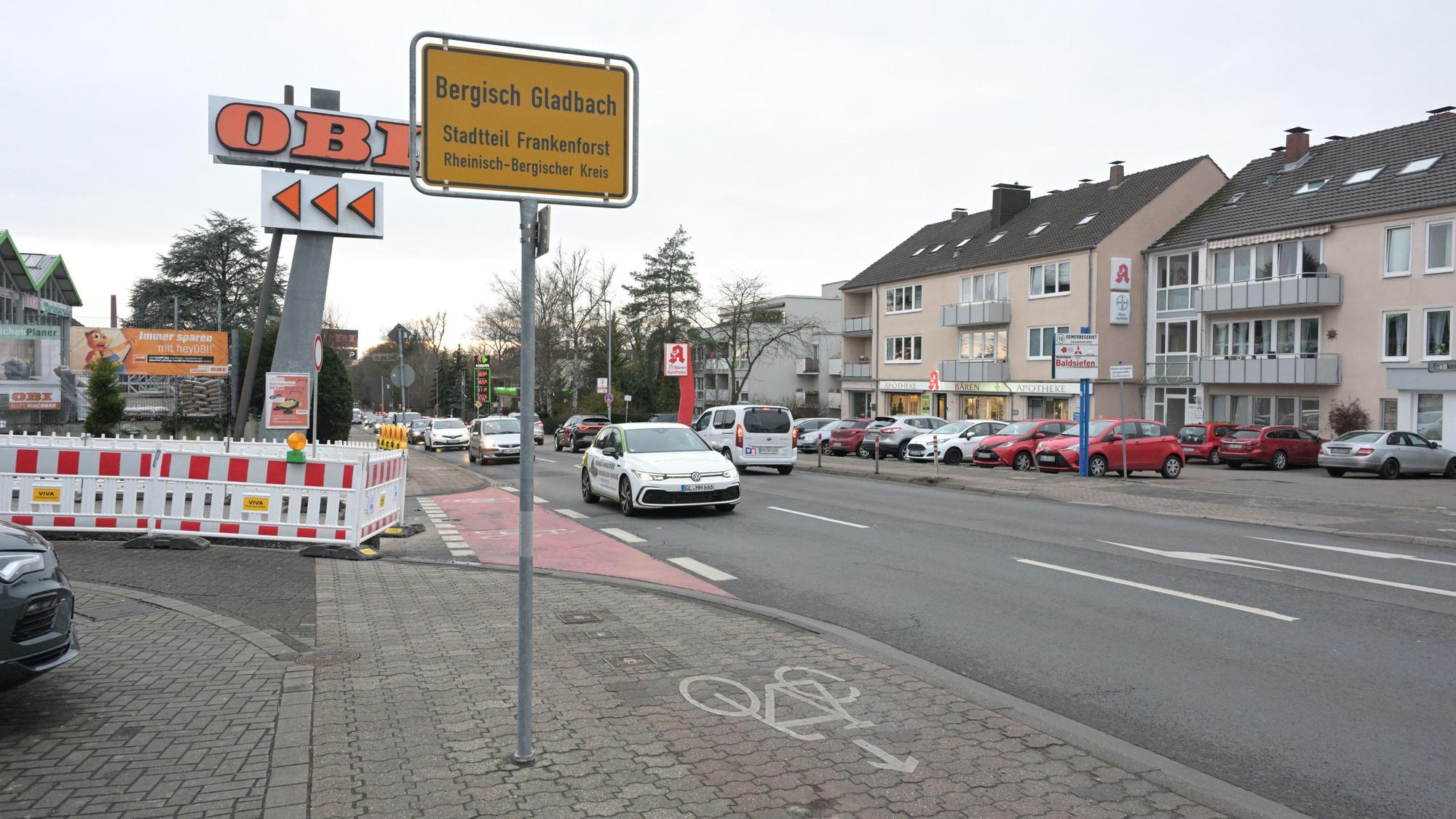 Ein gelbes Ortsschild mit dem Schriftzug„ Bergisch Gladbach“ steht neben einem Fahrradweg.