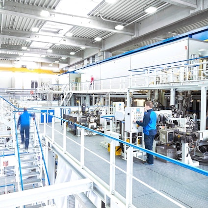 Der Blick in eine hochmoderne und eine sehr saubere Fabrikhalle mit Maschinen.