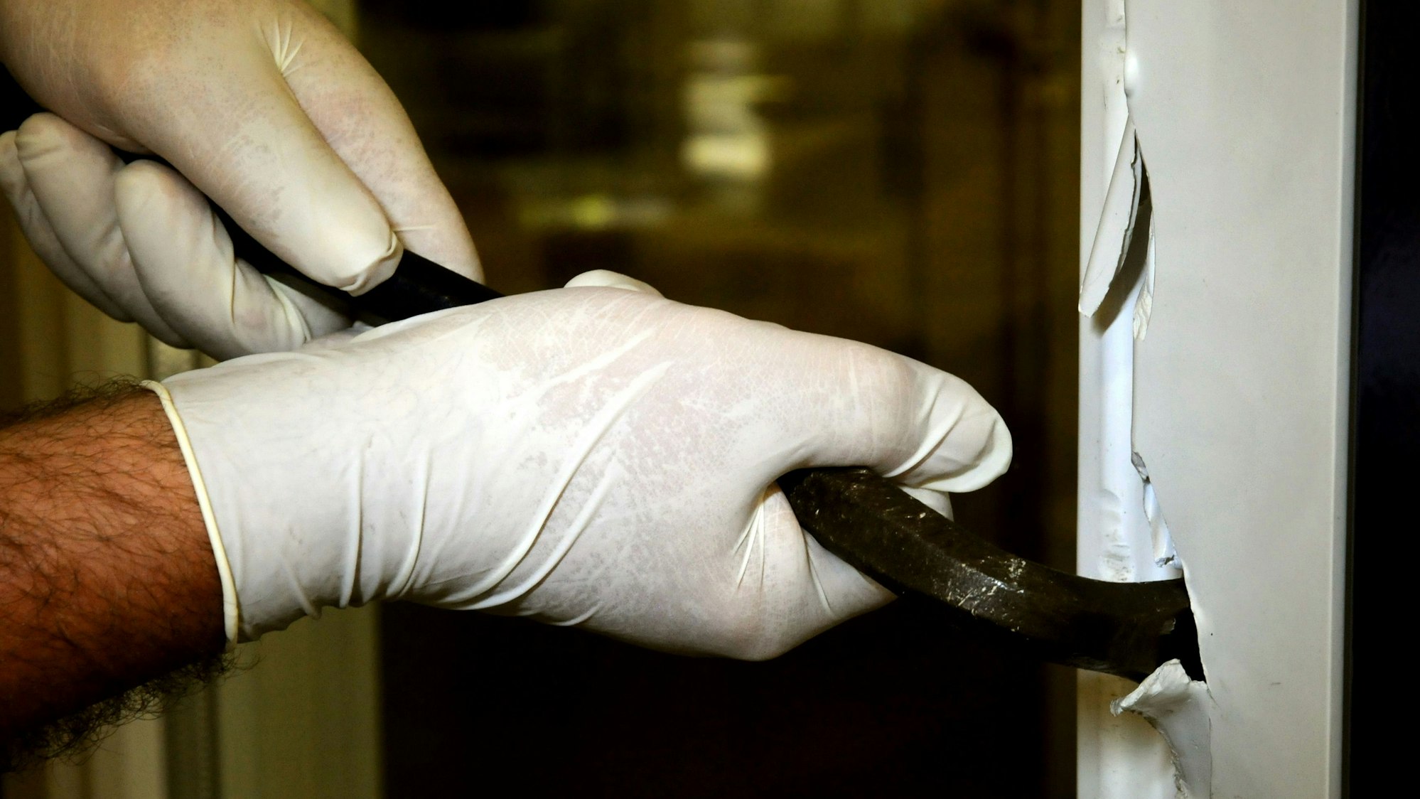 Ein Einbrecher hebelt eine Tür auf (Symbolfoto).