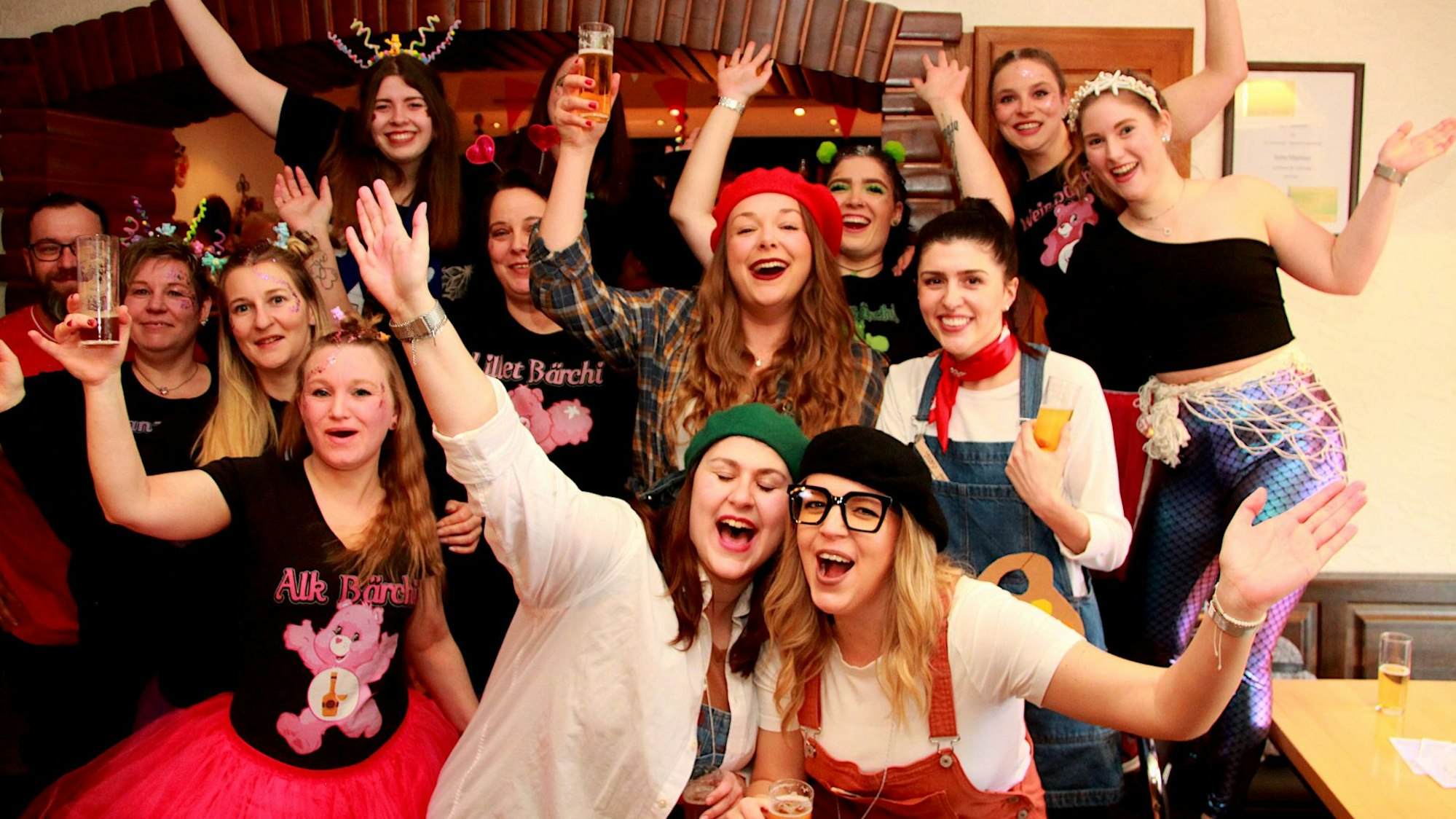 Kostümierte Frauen feiern ausgelassen Karneval, einige haben ein Bierglas in der Hand.