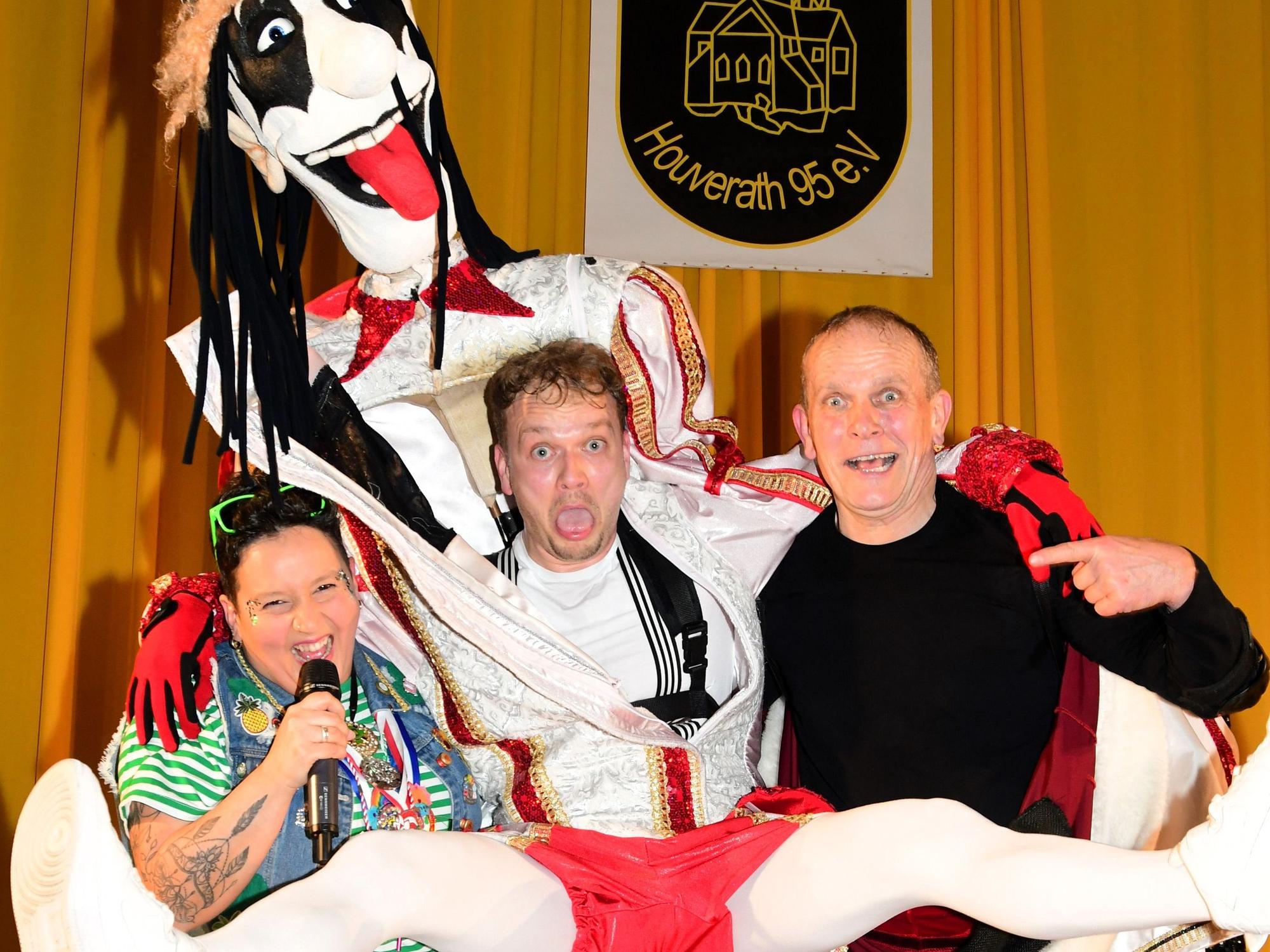 Gerd Waree steckt in einer übergroßen Prinzenfigur und vollführt einen Sprung, daneben stehen Ramona Reuter und Dustin Waree.