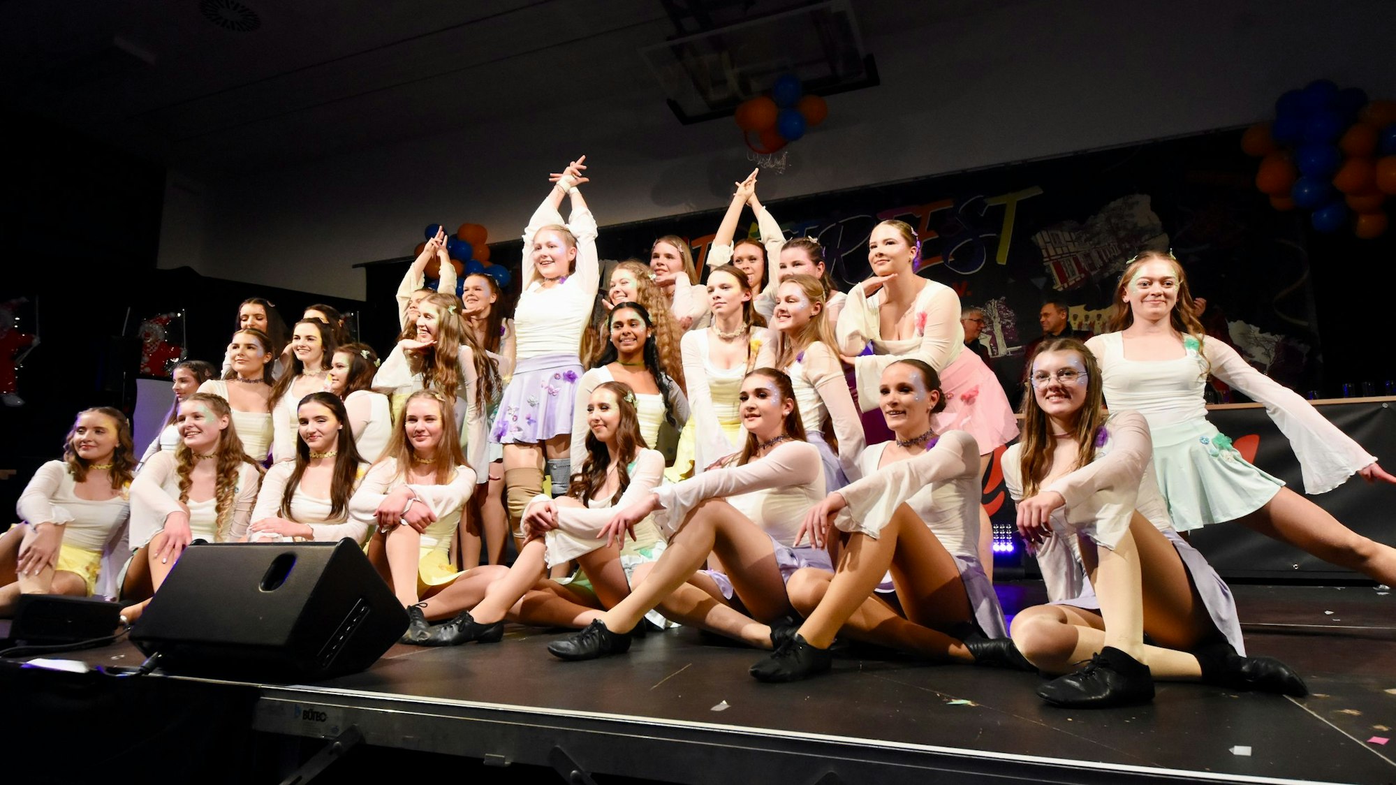 Frauen und Mädchen in Tanzkostümen in ihrer Schlusspose.