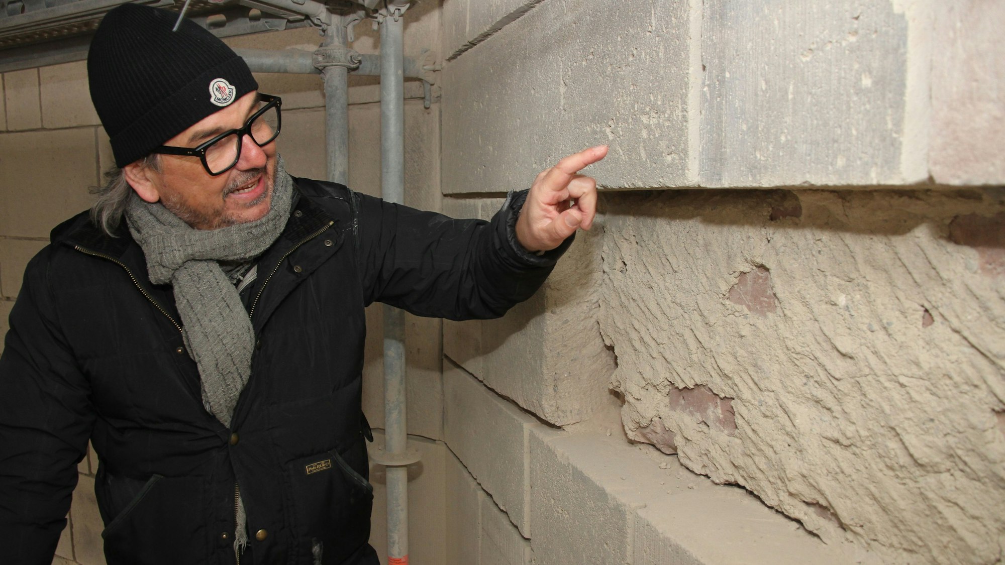 Ein Mann vor einem Mauerwerk mit Fassadenplatten.