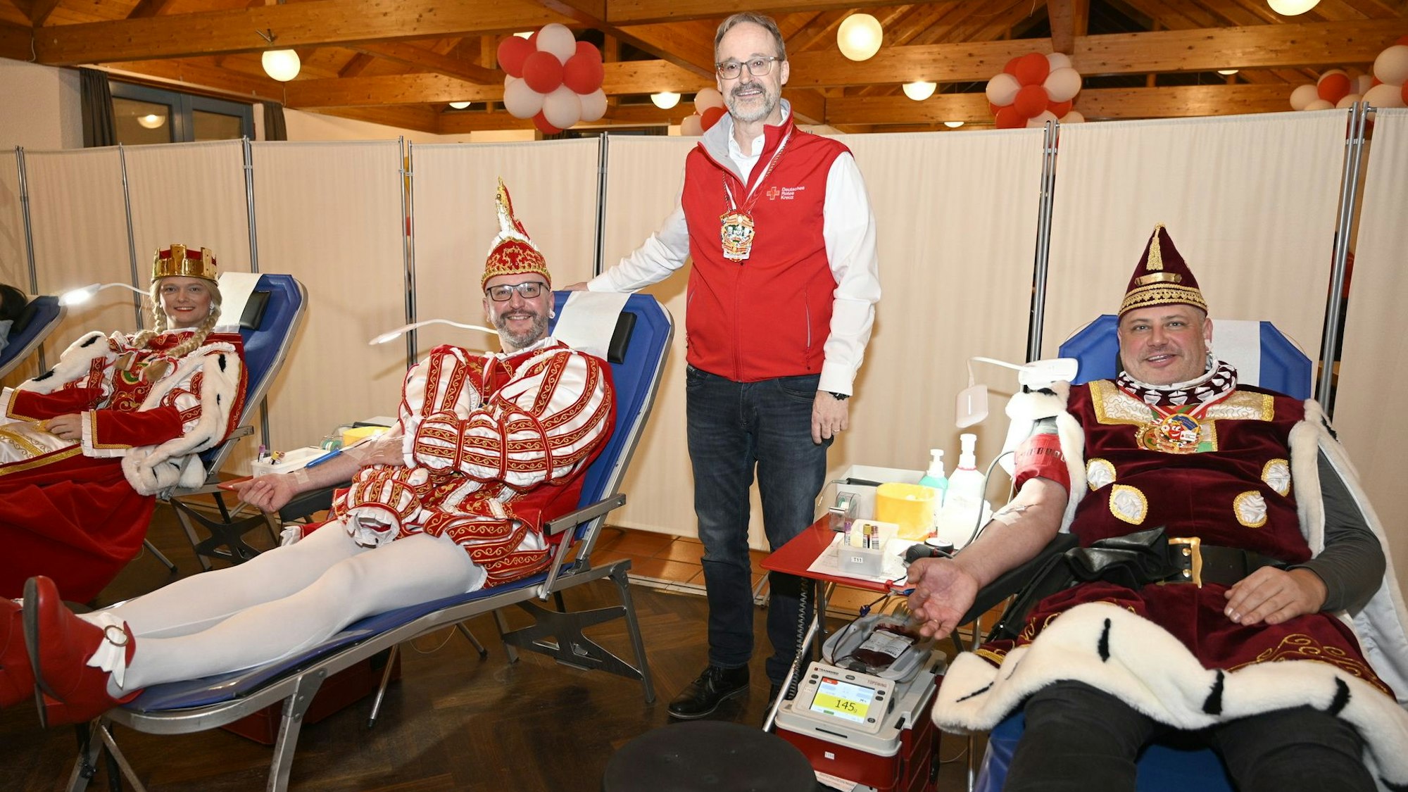 Rolf Klöcker steht, Prinz, Bauer und Jungfrau liegen und spenden Blut.