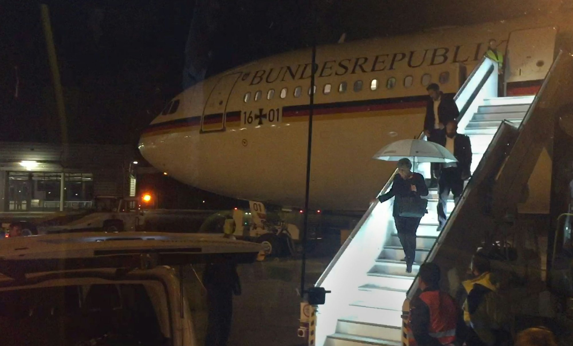 29.11.2018, Nordrhein-Westfalen, Köln: Bundeskanzlerin Angela Merkel (CDU) verlässt mit einem Regenschirm in der Hand auf dem Rollfeld des Flughafens in Köln den Kanzler-Airbus „Konrad Adenauer“.