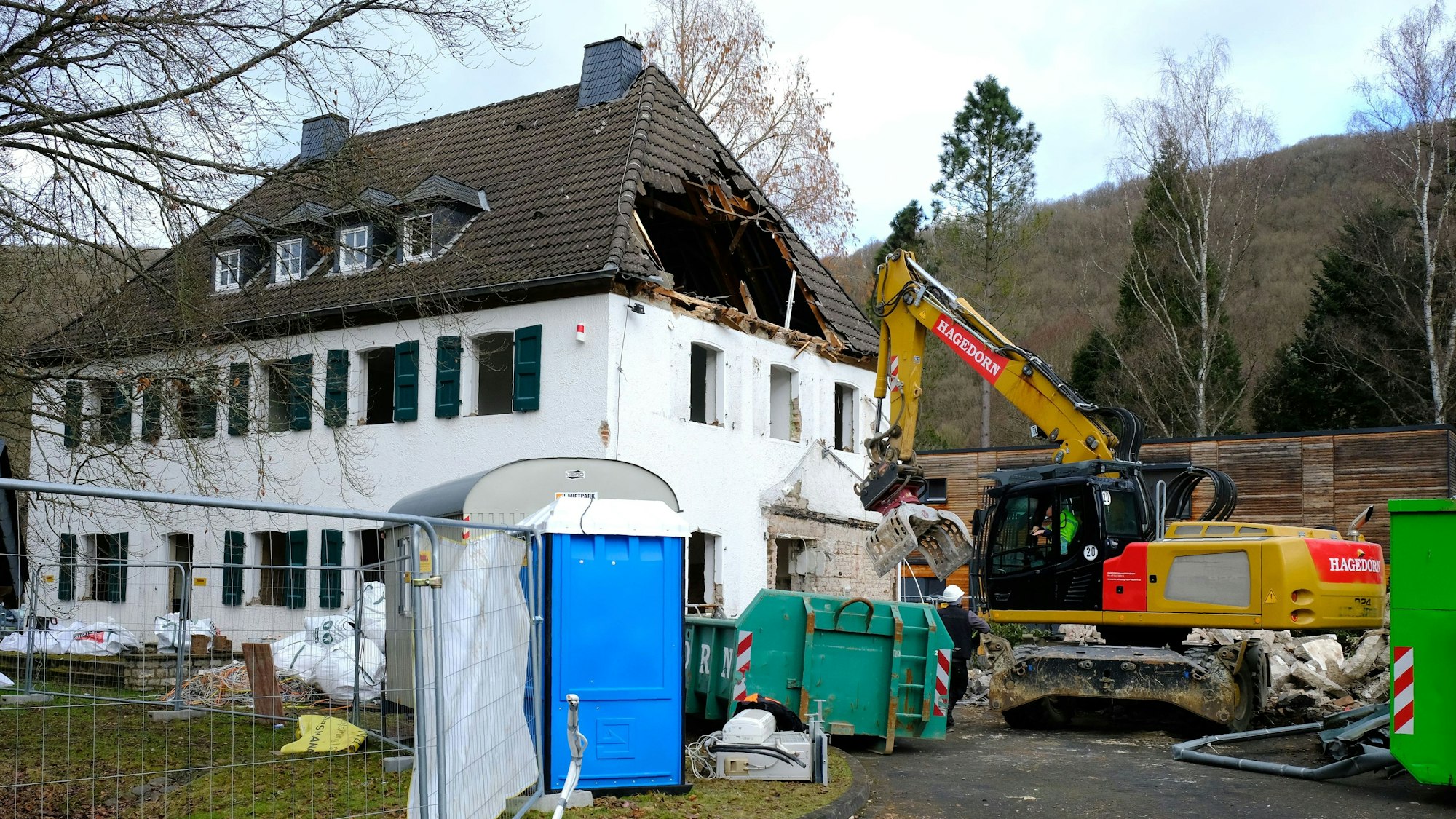 Das alte Gebäude des Nationalpark-Forstamts wird abgerissen. Im Dachstuhl klafft bereits ein Loch, vor dem Gebäude steht ein Bagger.