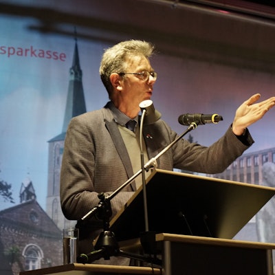 Das Bild zeigt Klaus Ripp an einem Pult.