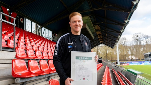 Marian Wilhelm, künftiger Cheftrainer von Viktoria Köln, hält seine Pro-Lizenz-Urkunde in den Händen.