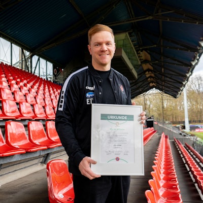 Marian Wilhelm, künftiger Cheftrainer von Viktoria Köln, hält seine Pro-Lizenz-Urkunde in den Händen.