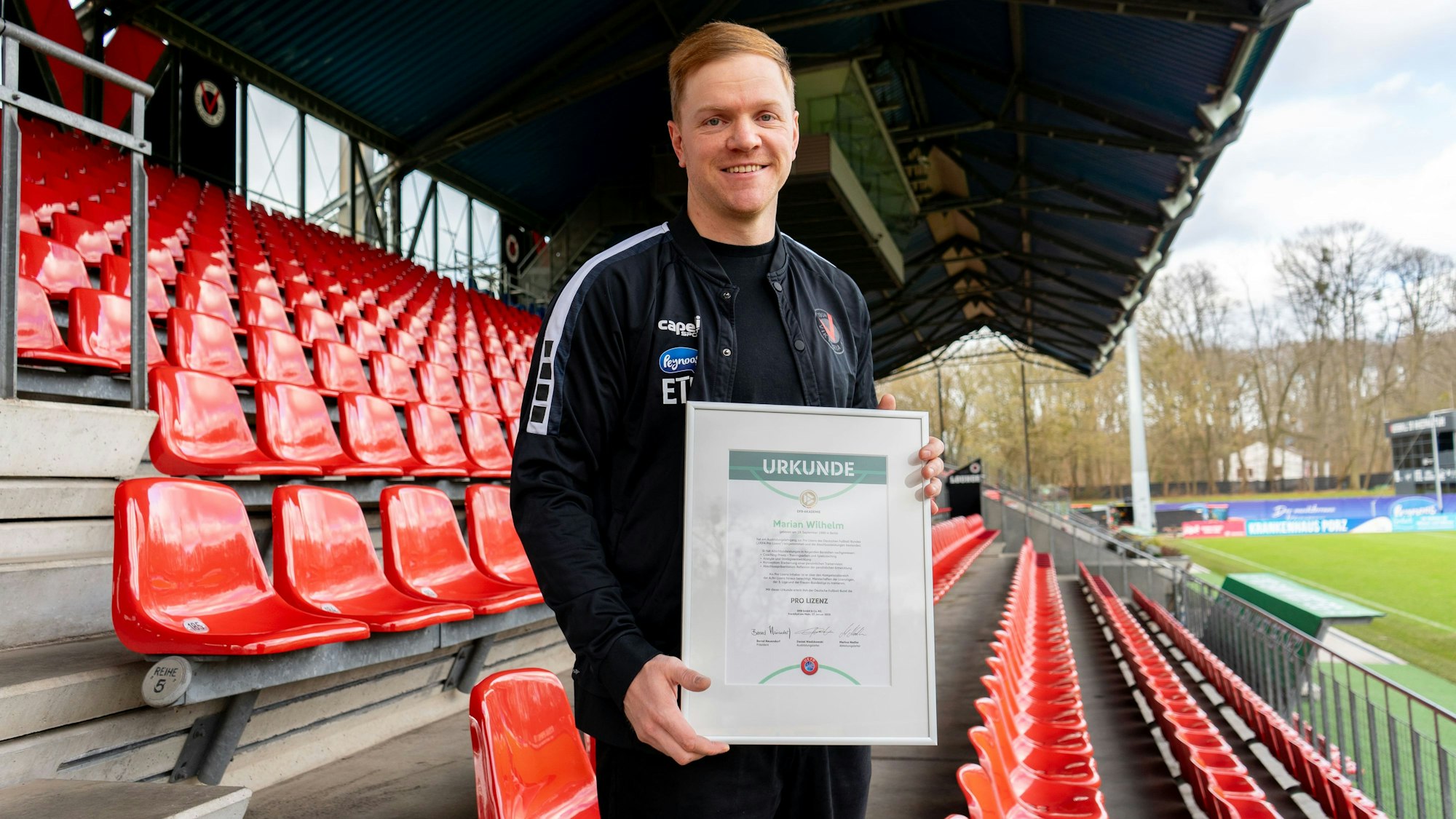 Marian Wilhelm, künftiger Cheftrainer von Viktoria Köln, hält seine Pro-Lizenz-Urkunde in den Händen.