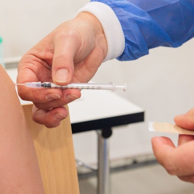 Zu sehen ist der Oberarm eines Menschen, in dem eine Spritze steckt.