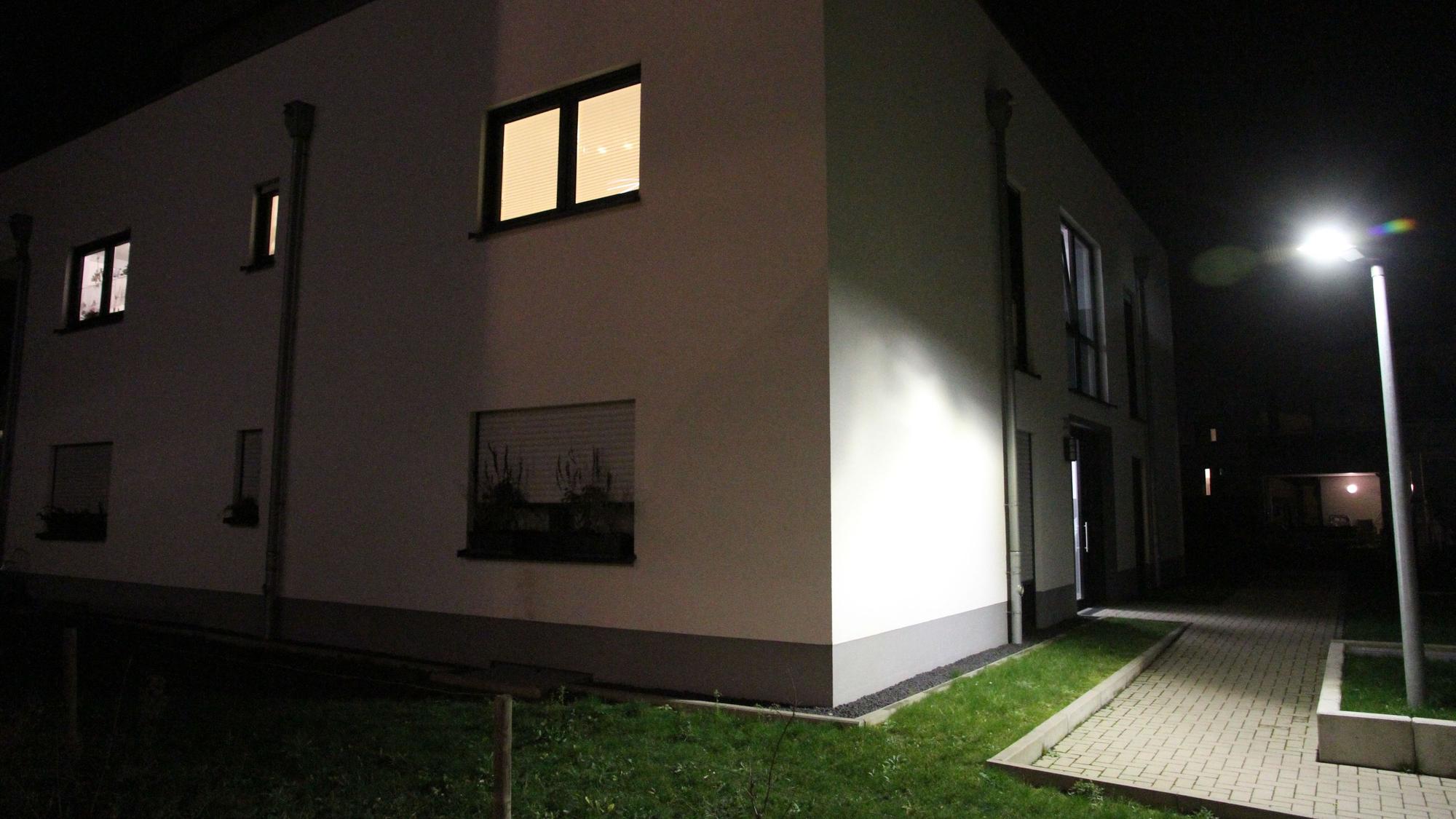 Ein Wohnhaus in der Nacht neben einer Straßenlaterne.