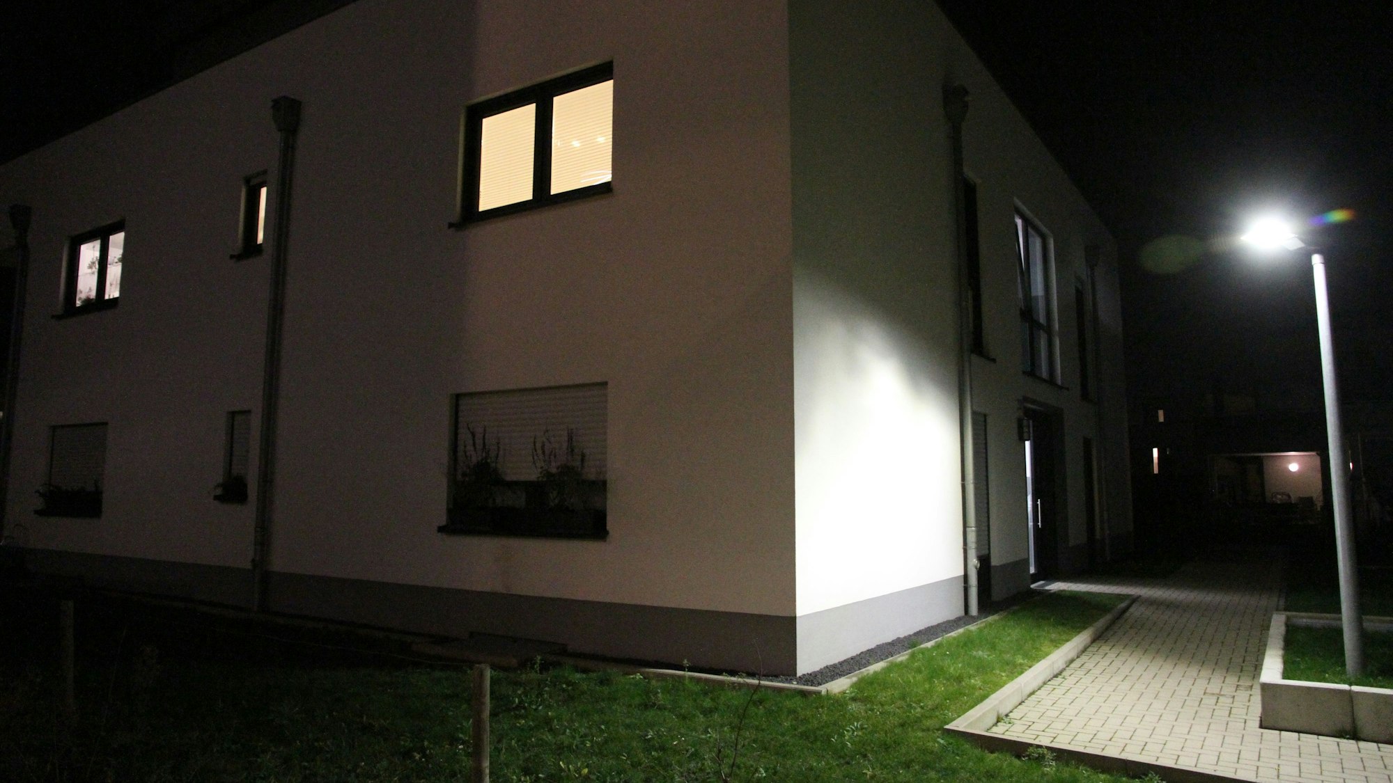 Ein Wohnhaus in der Nacht neben einer Straßenlaterne.