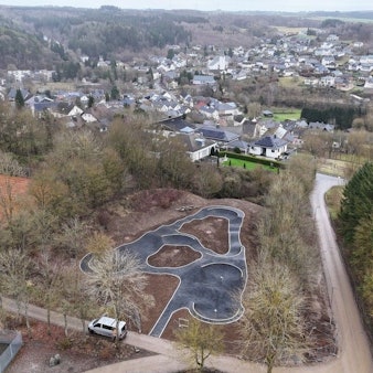 Das Luftbild zeigt den neuen Pumptrack in Nettersheim. Im Hintergrund ist der Ort zu sehen.