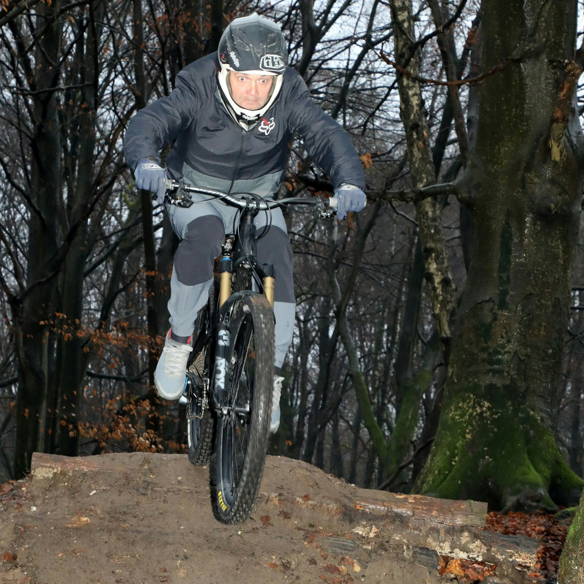 Christian Althaus fährt auf einem Mountainbike über eine Sprungschanze im Nußbaumer Wald von Bergisch Gladbach.