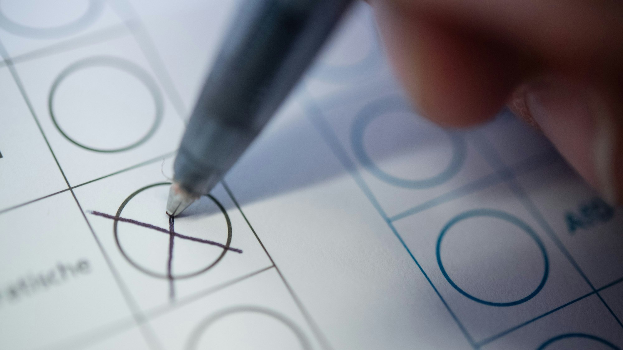 Eine Frau macht ein Kreuz auf einem Wahlzettel. (Symbolbild)