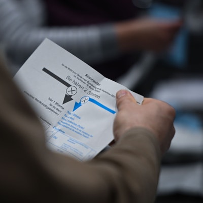 ARCHIV - 11.02.2024, Berlin: Ein Wahlhelfer hält während der Auszählung der Briefwahlstimmen in der Max-Schmeling-Halle einen Stimmzettel in der Hand.