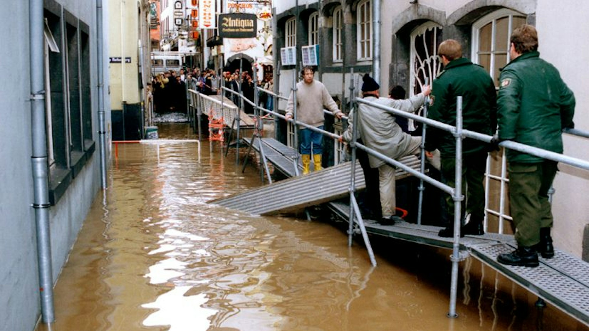 Ein Metallsteg führt über das Wasser durch die Kölner Altstadt.