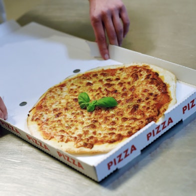 Das Foto zeigt eine Pizza im Karton.