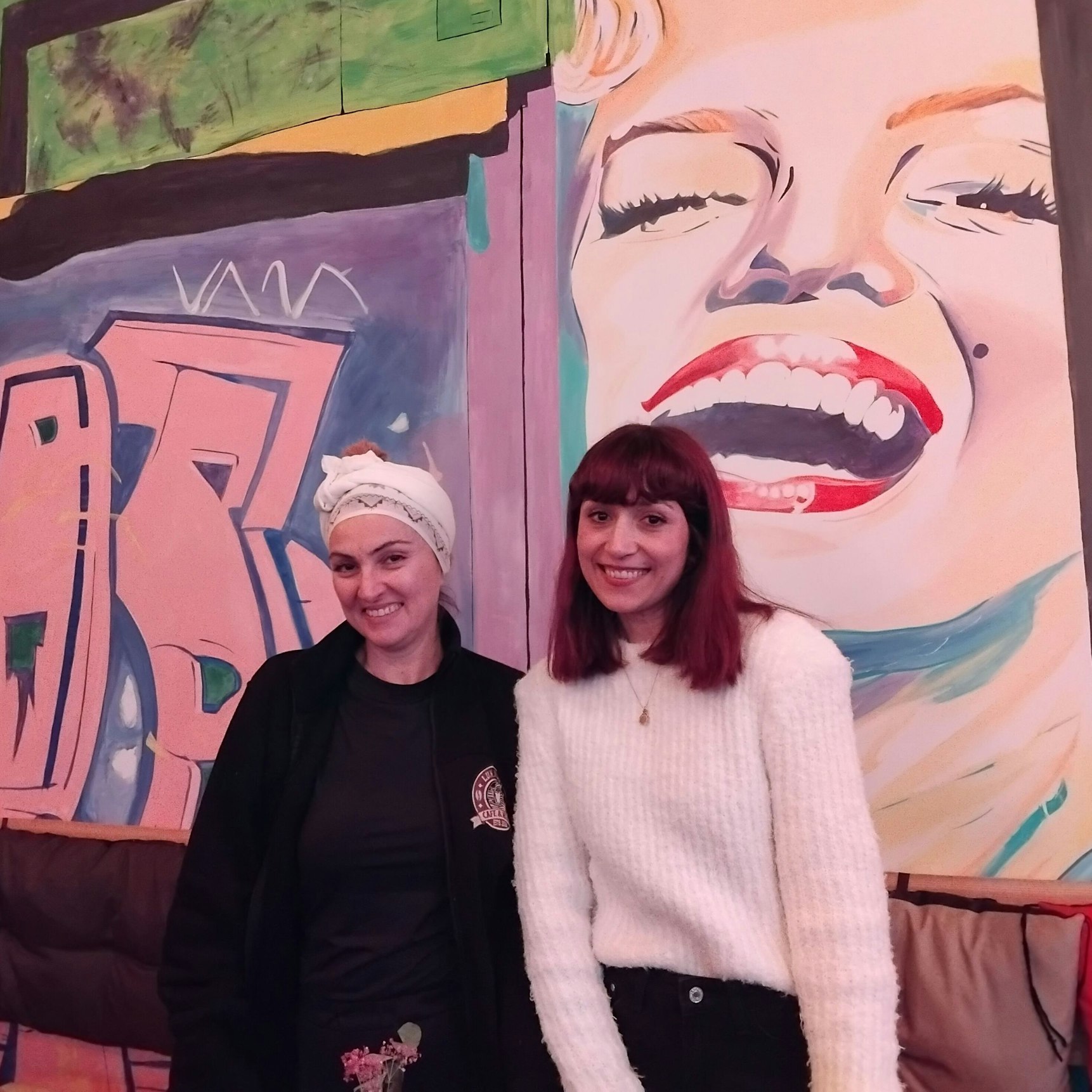 Zwei Frauen vor einer bunt bemalten Wand