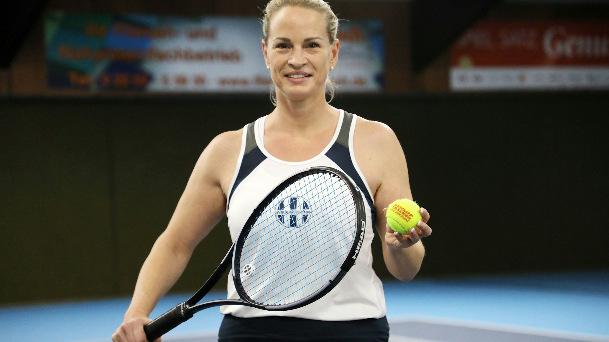 Stephanie Müller steht mit Tennisschläger und Ball in der Tennishalle von Blau-Weiß Hand.