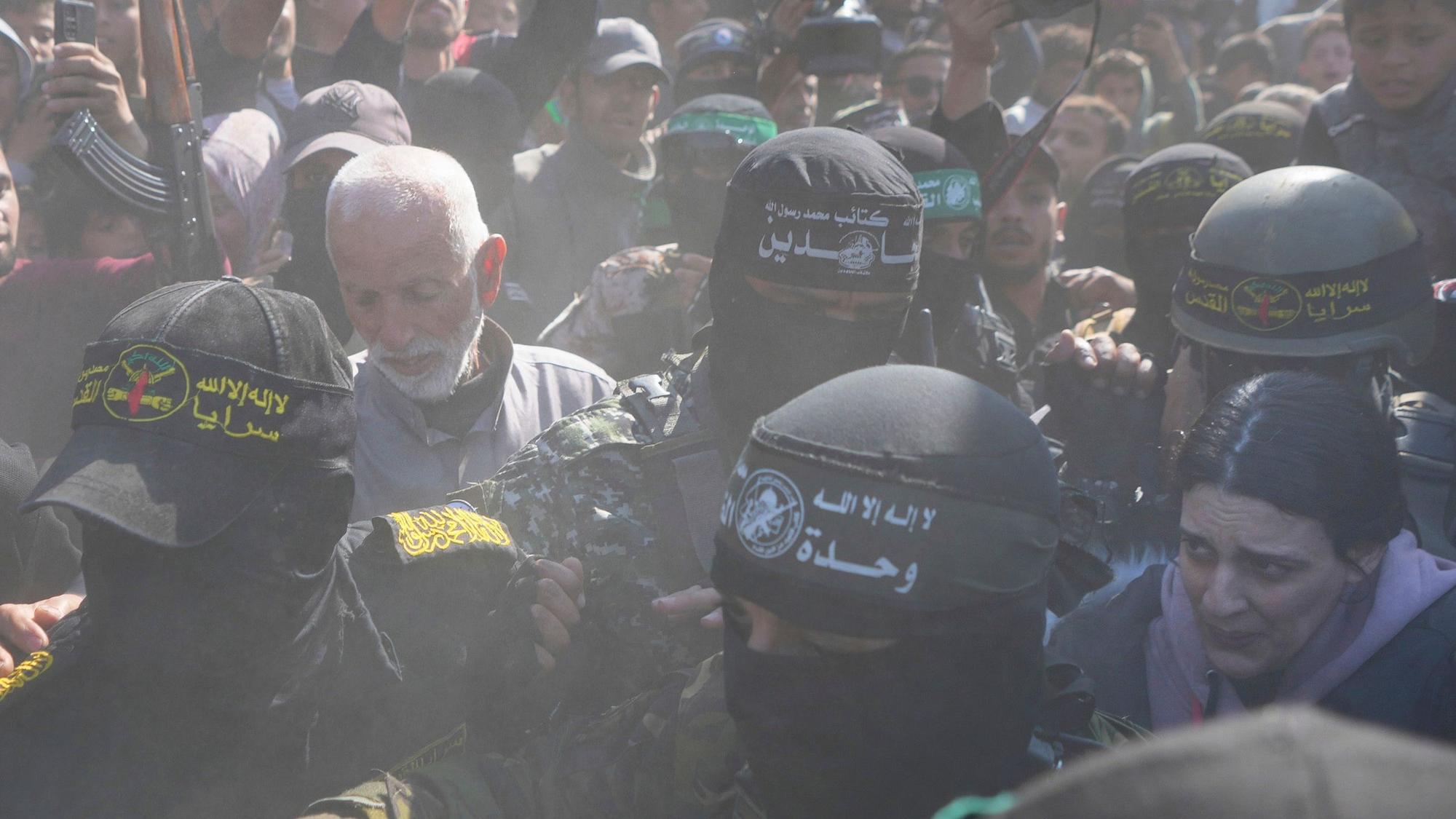 30.01.2025, Palästinensische Gebiete, Chan Junis: Die Deutsch-Israelin Arbel Yahud (vorn r.), die seit dem 7. Oktober 2023 von der Hamas im Gazastreifen als Geiseln festgehalten wurde, wird von Kämpfern der Hamas und des Islamischen Dschihad eskortiert, als sie dem Roten Kreuz übergeben werden. Foto: Abdel Kareem Hana/AP/dpa +++ dpa-Bildfunk +++