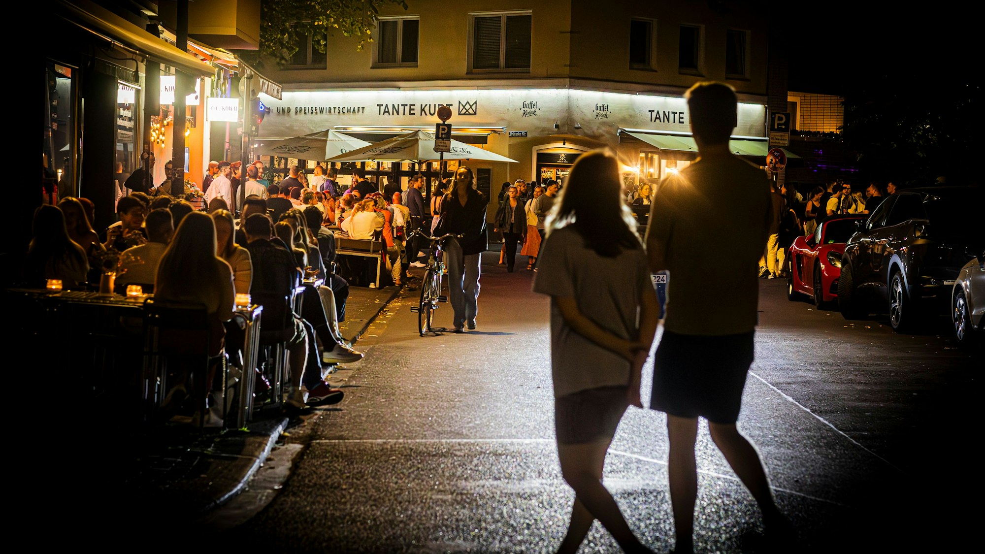 Menschen stehen nachts am Brüsseler Platz in Köln.