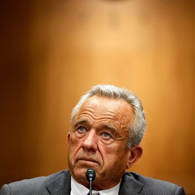 Portrait von Robert Kennedy, der hinter einem Mikrofon sitzt