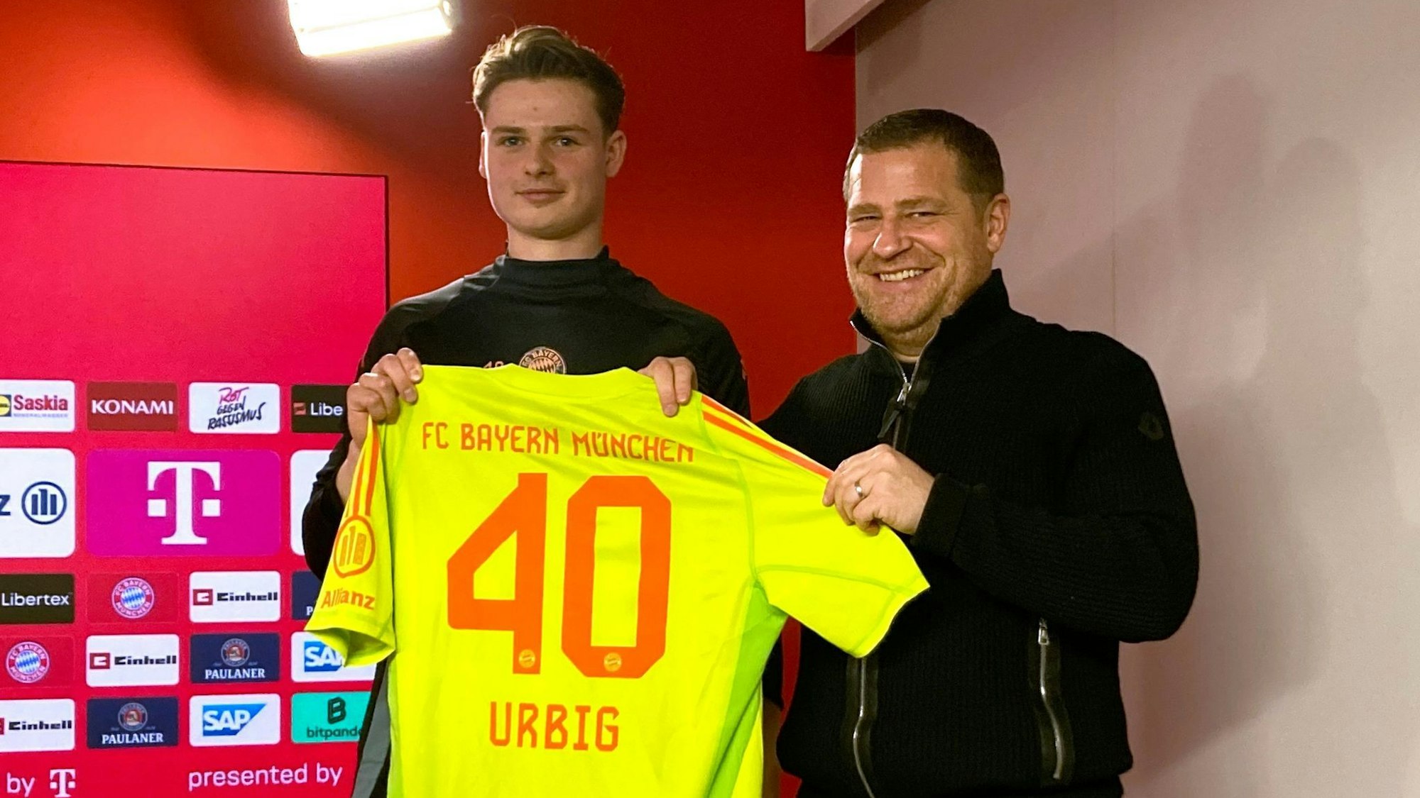 Jonas Urbig (l) präsentiert das Bayern-Trikot mit der Nummer 40 bei seiner Vorstellung mit Sportvorstand Max Eberl.