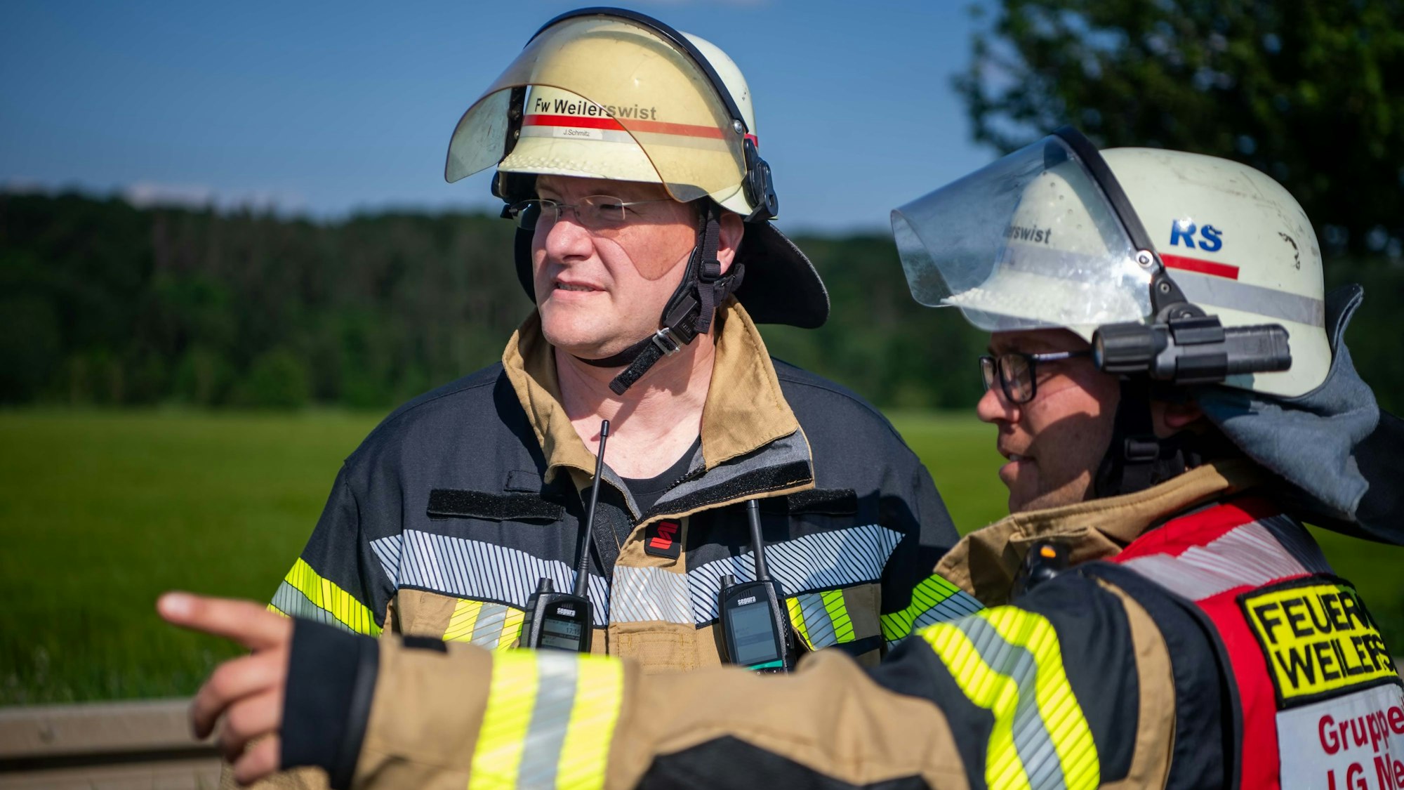 Das Bild zeigt den Gemeindebrandinspektor Jürgen Schmitz (l.) bei einem Einsatz im Gespräch.