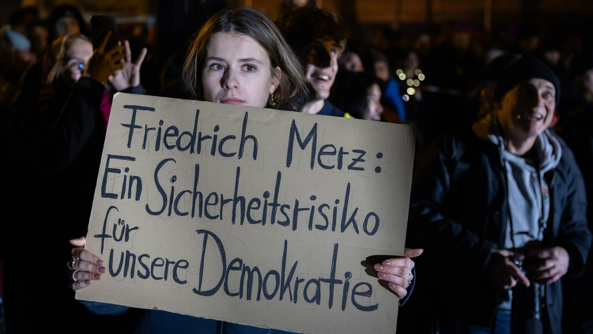 Luisa Neubauer, Klimaaktivistin, hält bei einer Kundgebung gegen die Migrationspläne von Union und AfD vor der CDU-Bundesgeschäftsstelleein Plakat.