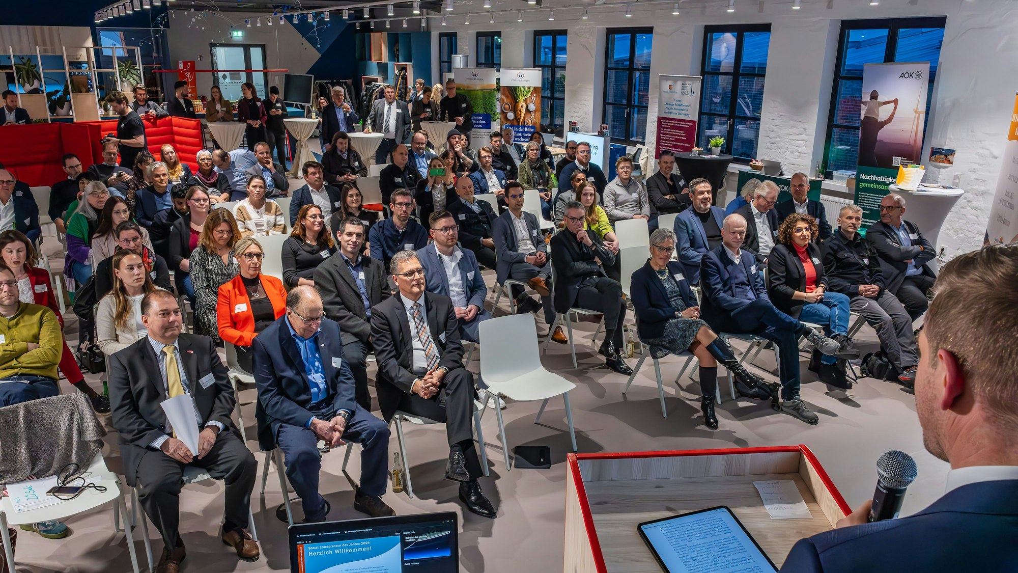 Am Rednerpult begrüßt Landrat die Gäste im Saal der Ideenfabrik.