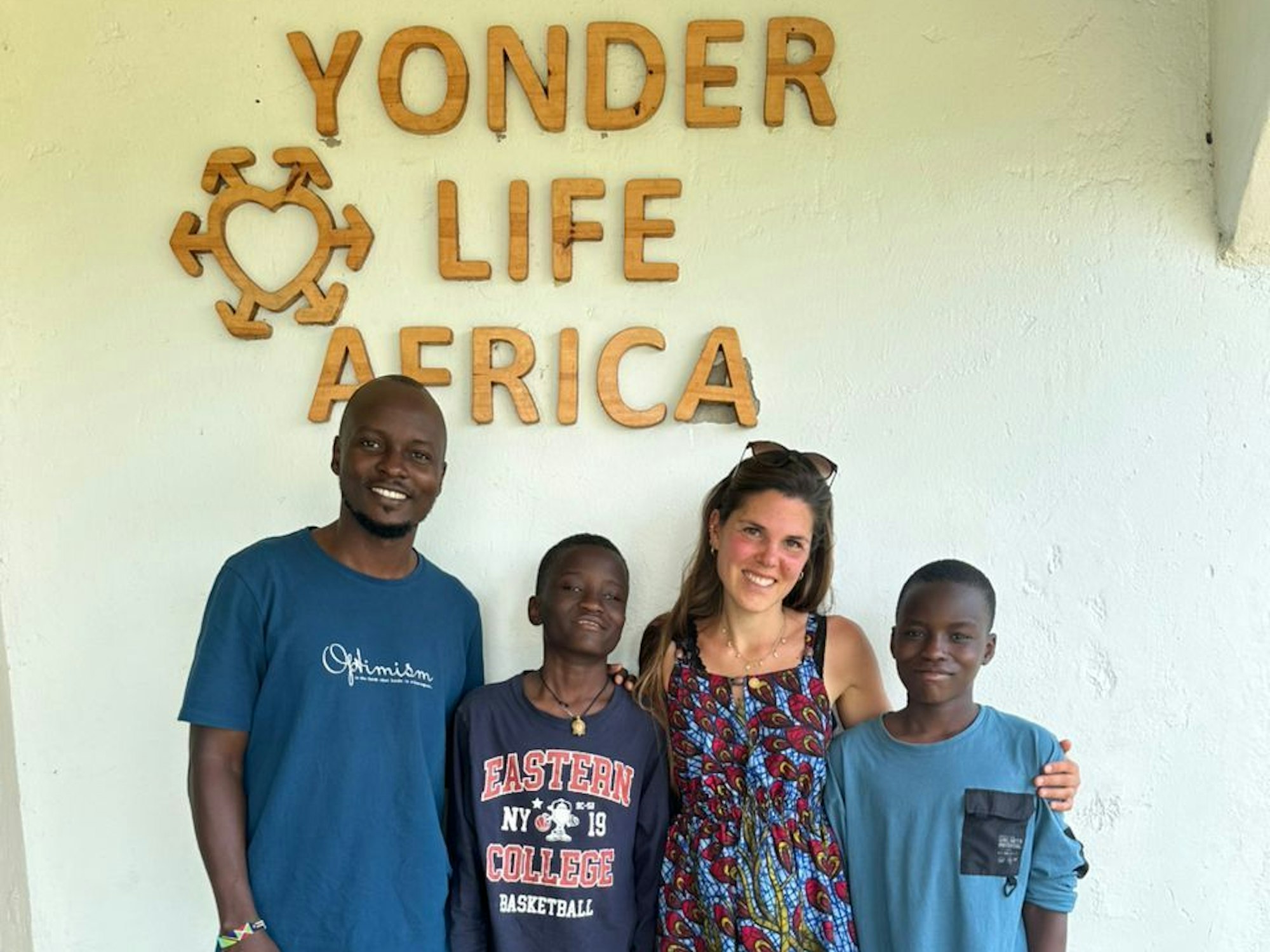 Eine Frau, ein Mann und zwei Kinder stehen vor einer Wand und lächeln in die Kamera.