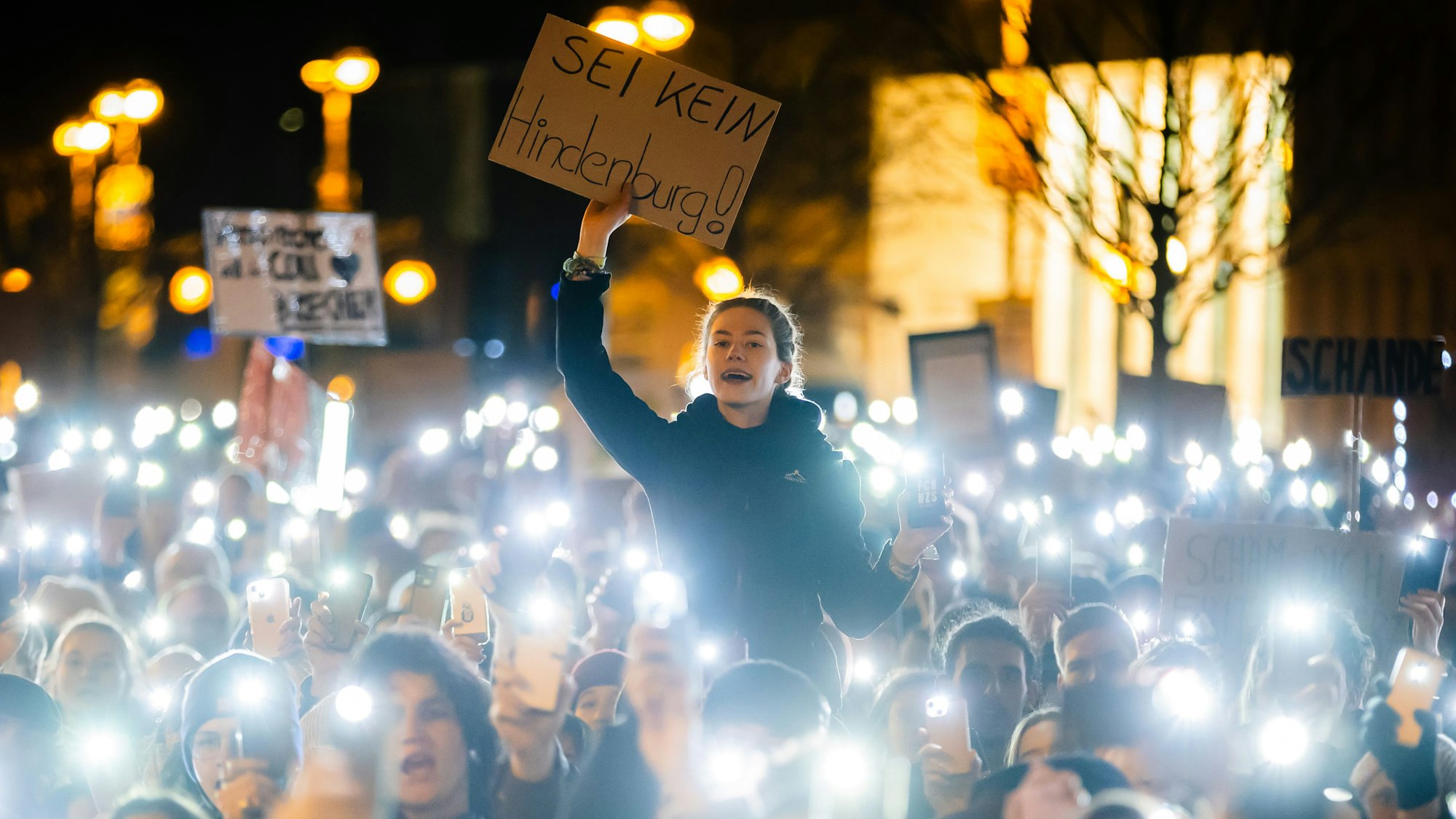 Eine Teilnehmerin hält bei einer Kundgebung gegen die Migrationspläne von Union und AfD vor dem Konrad-Adenauer-Haus ein Plakat. Mehrere Tausend Menschen demonstrierten am Donnerstagabend vor der CDU-Bundesgeschäftsstelle.