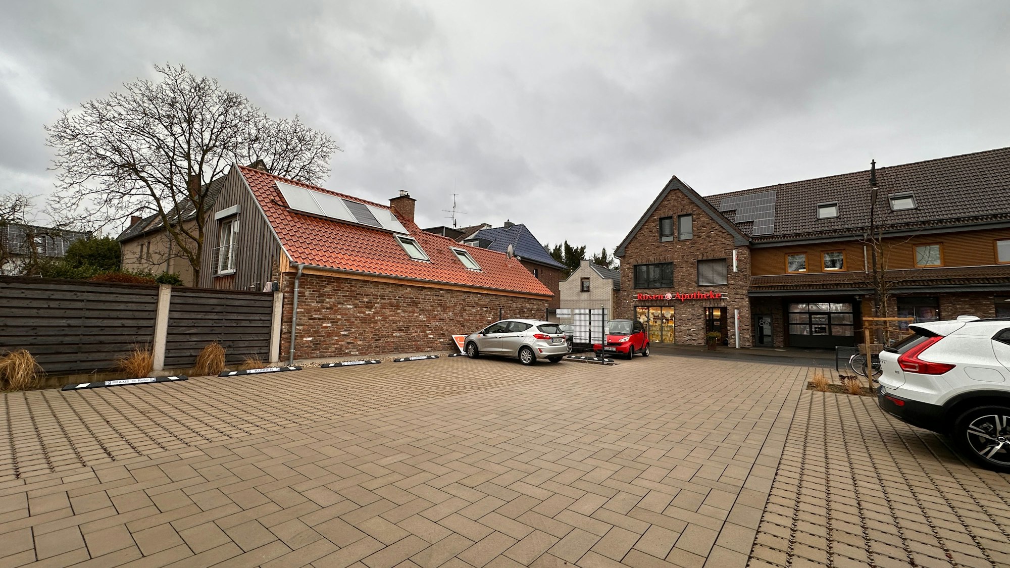 Auf einem großen Parkplatz stehen wenige Autos.