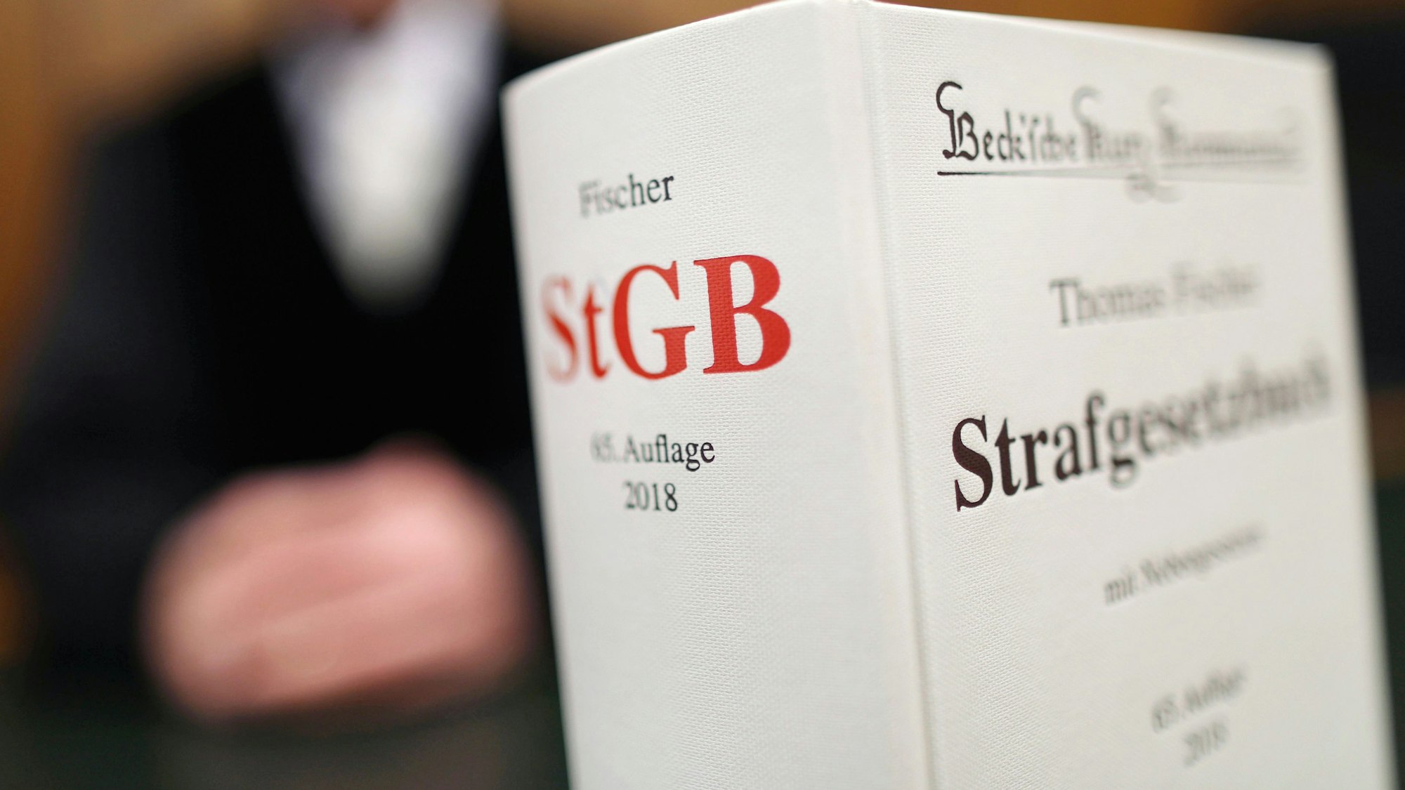 Ein Strafgesetzbuch (StGB) steht im Gericht auf der Richterbank.
